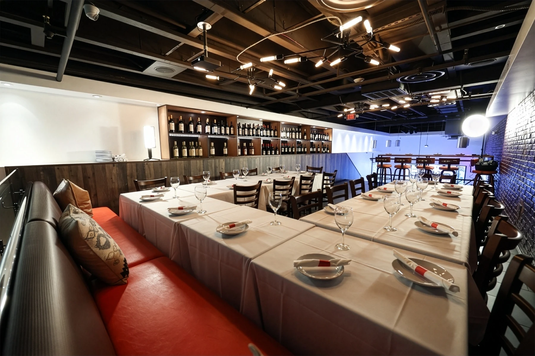 The private banquet room set with long linen tables, wine wall and red banquette seating